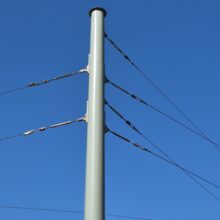 Während ein traditioneller Lichtmast im oberen Bereich einen Durchmesser von 76 mm hat, beträgt dieser Durchmesser beim vorliegenden Mast 205 mm. Dadurch und durch die entsprechend statisch dimensionierte Wandstärke wird sichergestellt, dass der Spitzenzug aufgenommen werden kann und die Auslenkung deutlich kleiner bleibt als bei Beleuchtungsmasten.